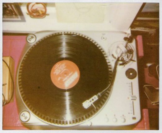 A dark brown, 20th century style record on a white record player. 